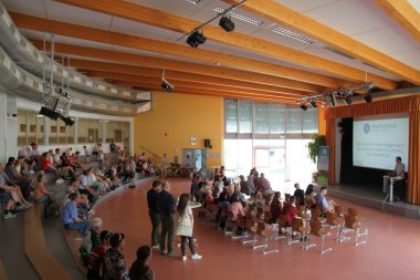 Bild zeigt Aula mit Menschen bei der Abschlussveranstalung